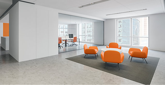 A reception area with a white table and orange chairs
