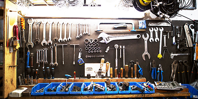 tools hang on the wall in a workshop