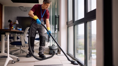 Office cleaner uses a commercial vacuum cleaner in the boardroom
