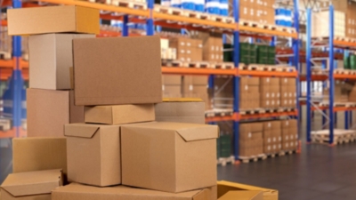 Cardboard box packaging stacked in a large industrial warehouse