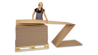 Flat-packed folded cardboard being assembled into cardboard boxes