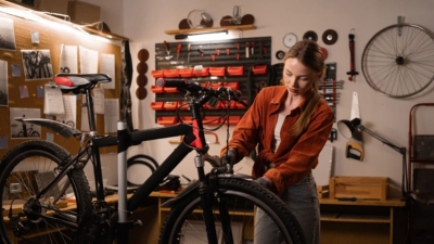 Woman carrying out bicycle maintenance in her home workshop
