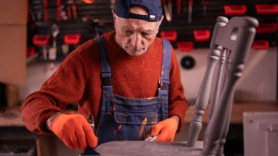 Man refurbishing an old dining room chair in his home workshop