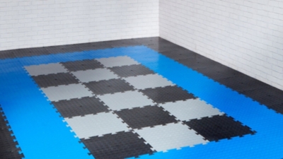 Modern garage flooring using interlocking floor tiles in black, blue and grey