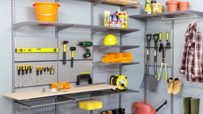 Wall-mounted garage shelving with adjustable shelves fitted to a track system, holding workshop and DIY equipment