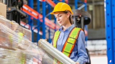 Warehouse worker uses stretch film to wrap a pallet for delivery