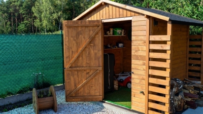 Garden shed with door open and well-organised shelves and storage inside