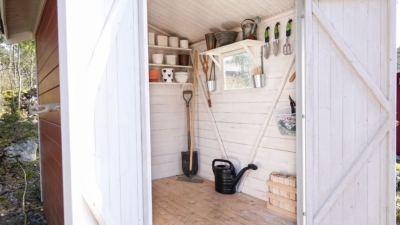 Garden shed with door open and wall-mounted storage shelves inside