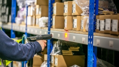 Warehouse worker uses inventory barcode scanner while picking orders
