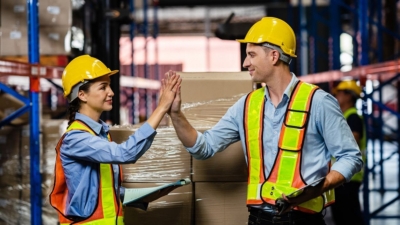 Two warehouse employees celebrate completing a refresher training course