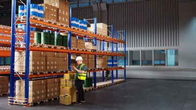 Warehouse worker picking an order at some tidy, well-organised warehouse racking