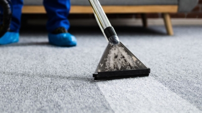 Janitor wearing disposable shoe covers uses a professional carpet cleaner
