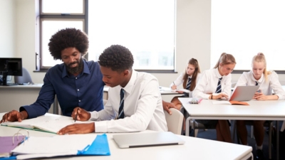Secondary school pupils studying at the classroom desk